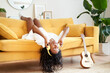 © CarlosBarquero - Motivated young woman with headphones sitting on sofa at home.