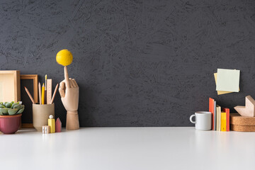 Poster - Creative desk with notebook, desk objects, office supplies, books, and cactus on a dark blue background..