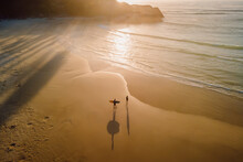 Warm Sunrise On Ocean With Shadow By Surfers And Waves. Joaquina Beach In Brazil
