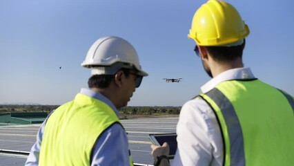 Wall Mural - professional engineer using drone and digital tablet maintaining solar cell panels together on build