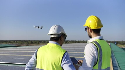 Wall Mural - professional engineer using drone and digital tablet maintaining solar cell panels together on build