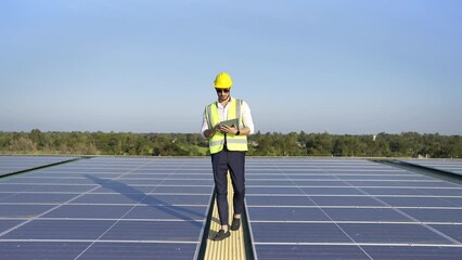 Wall Mural - professional man engineer using tablet maintaining solar cell panels on building rooftop. technician
