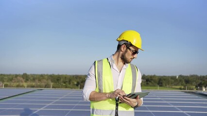 Wall Mural - professional man engineer using tablet maintaining solar cell panels on building rooftop. technician