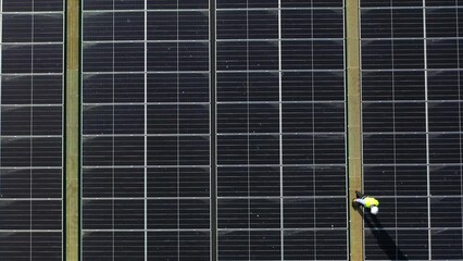 Wall Mural - professional engineer using drone and digital tablet maintaining solar cell panels together on build