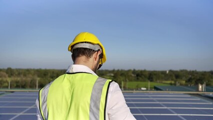 Wall Mural - professional man engineer using tablet maintaining solar cell panels on building rooftop. technician