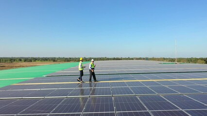 Wall Mural - professional engineer using drone and digital tablet maintaining solar cell panels together on build