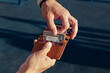 A man on the street is holding an open small comfortable red leather wallet with dollar bills and plastic cards. Blue background, horizontal orientation, copy space, close-up, no face