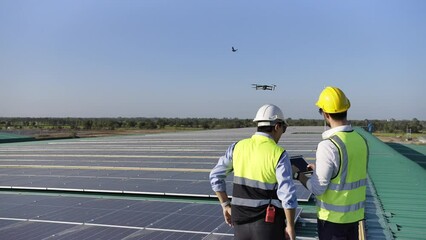 Wall Mural - professional engineer using drone and digital tablet maintaining solar cell panels together on build