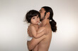 © Antonio Tanaka - portrait of a hispanic father and son hugging on a white background