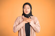 muslim woman close eyes holding chest while feeling relieved