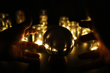 Black background with a ball and candles. Divination and prediction of fate.