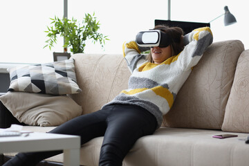 Female lay casually on couch in vr glasses, use modern device at home, test new development