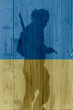 shadow of soldier in a wooden gate in the colors of the Ukrainian flag