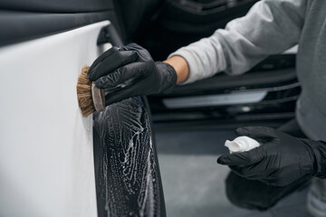 Wall Mural - Worker using automotive soap and brush for carwash