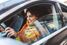 Young Woman Driving Car On Road Trip