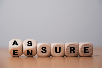 Fototapete -  Flipping wooden cube block for change between Assure and Ensure for Insurance and assurance concept.