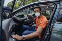 Man With Protective Face Mask In Car
