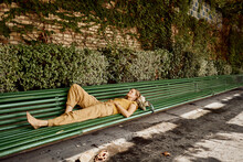 Woman Resting On Bench In Public Park