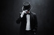 Mysterious man in black suit on dark background
