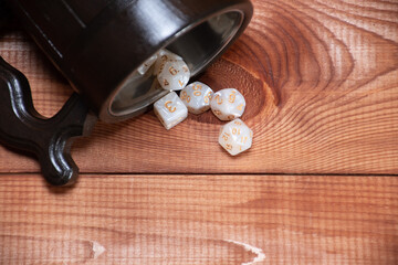 Wall Mural - Set of role playing white dices are falling from wooden  stylized beer mug for playing role-playing game on wooden background, top view with place for text, close up