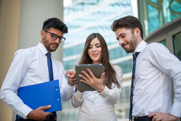 Wall Mural - Business people using a tablet outdoor