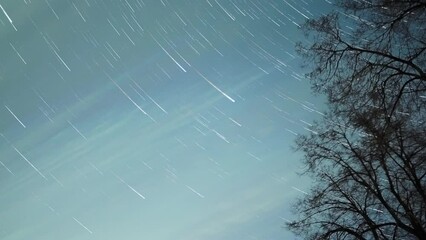 Wall Mural - Star trails in the cloudy night sky