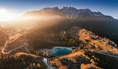 Wall Mural - Carezza, Italy - Aerial panoramic view of the Italian Dolomites with Lake Carezza (Lago di Carezza) and Latemar mountain at background on a sunny autumn sunrise