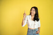© Odua Images - attractive asian woman with finger pointing up hand gesture