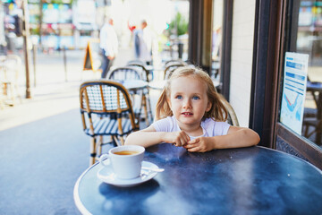 Wall Mural - Adorable three year old girl in Parisian cafe or restaurant