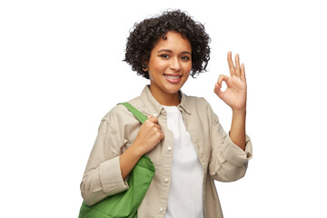 Wall Mural - eco living, zero waste and sustainability concept - portrait of happy smiling woman with green reusable canvas bag for food shopping showing ok gesture over white background