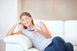 © Yuri A/peopleimages.com - Comedys my favourite genre. Young woman watching tv and laughing while changing the channel.