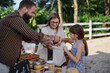 © Halfpoint - Happy little girl with mother buying vegetables outdoors at local family farmers market.