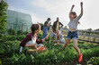 © Halfpoint - Happy farmers or gardeners working outdoors at community farm.