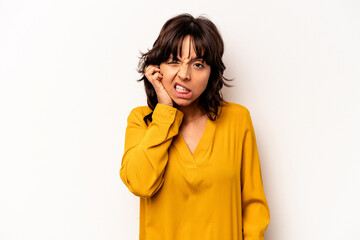 Young hispanic woman isolated on white background covering ears with fingers, stressed and desperate by a loudly ambient.