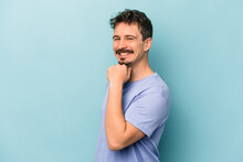 Young Caucasian Man Isolated On Blue Background Smiling Happy And Confident, Touching Chin With Hand.