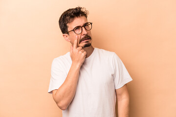Wall Mural - Young caucasian man isolated on beige background crying, unhappy with something, agony and confusion concept.
