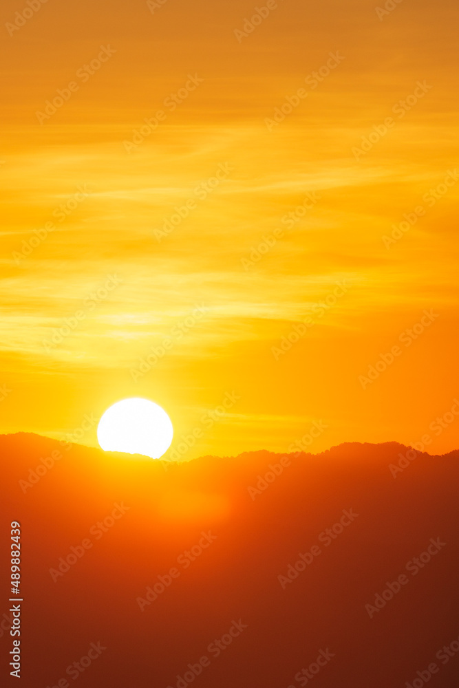 Closeup to sun over the mountain hill at sunrise time or morning 