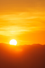 Wall Mural - closeup to sun over the mountain hill at sunrise time or morning time.