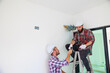© NVB Stocker - Two electricians and builder helping to install the electrical system in the house under construction. Maintenance service Repair and handyman concept