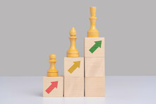 The Concept Of Career Growth. Chess Pieces Pawn, Officer, Queen On Wooden Cubes Arranged In The Form Of Stairs And Pyramids With Arrows Pointing Up.