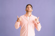 Portrait of confident young man head thrown back standing with proud posture, self confidence, high self esteem, accomplished, courageous expression on pink isolated background in studio.