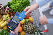 Woman paying for groceries using a credit card