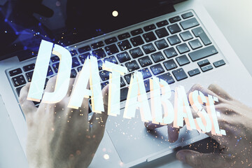 Wall Mural - double exposure of creative database word hologram and hands typing on laptop on background, researc