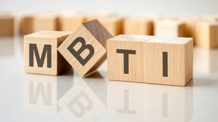 Poster - four wooden blocks with the letters MBTI on the bright surface of a gray table, business conceptual word collected of of wooden elements with the letters