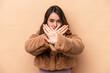 © Asier - Young caucasian woman isolated on beige background doing a denial gesture
