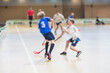 © tsuguliev - View of floorball match game, court hall indoor venue with junior teenage children school team playing in the background, floor ball hockey match game on arena stadium, copy space