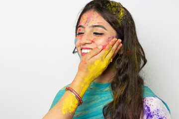 Wall Mural - Holi colour powder being applied by a woman on Young indian smart girl face for festival of colours Holi, a popular hindu festival celebrated across india, isolated over white background