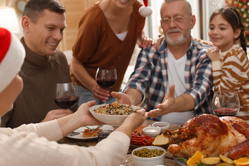 Wall Mural - Woman giving bowl of traditional Christmas Slavic dish kutia to man during festive dinner at home