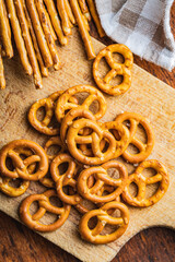 Wall Mural - Mini pretzels and salted sticks. Crusty salted snack on cutting board.