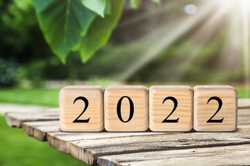 Sticker - Happy New Year 2022 concept with wood cube block and nature background